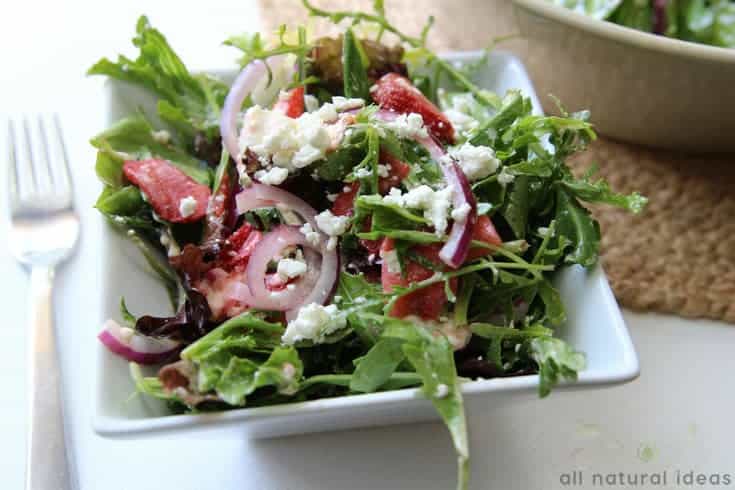 Serving an easy spinach strawberry walnut salad