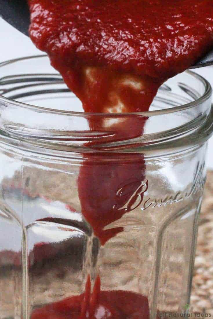 Pouring homemade paleo ketchup into jar