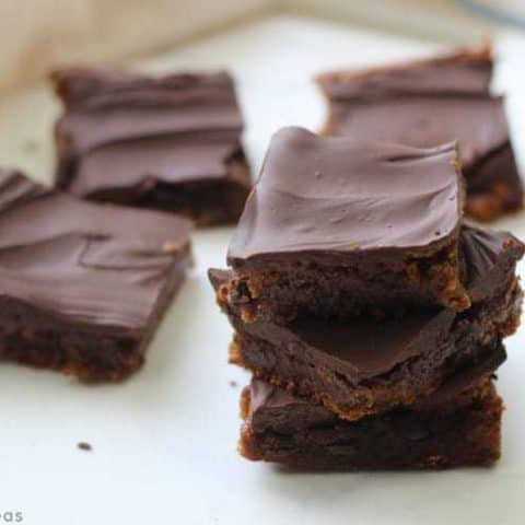 Stack of chocolate covered paleo almond butter brownies