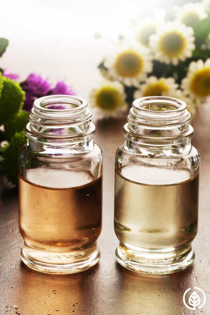 Essential oil bottles with flowers in back